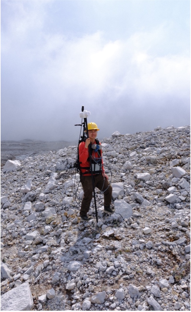 Lee wearing the magnetic surveying rig, with the GSM-19 magnetometer seen as the white block at the top of the staff. Photo: Conor Bacon