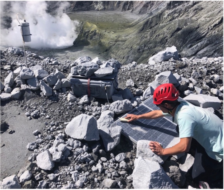Avard cleaning ash from the solar panels at the MultiGAS site on the western crater rim. Photo: Terry Plank